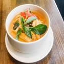 Warm, color-graded backdrop evoking Silver Spoon's red curry — chili red and jade tones